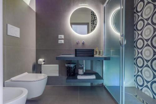 a bathroom with a toilet and a sink and a mirror at Le dimore di Calù in San Donato di Lecce