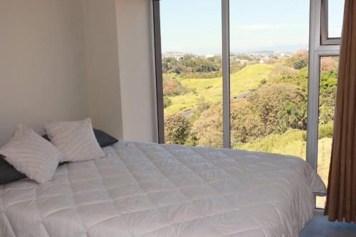 um quarto com uma cama branca e uma grande janela em Condo in San José em San José