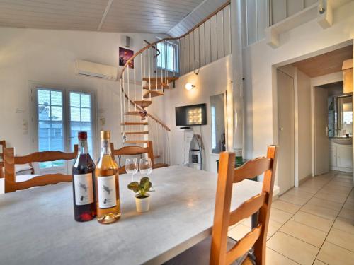 - une salle à manger avec une table et des bouteilles de vin dans l'établissement Holiday Home Douce Alouette by Interhome, à Dolus-d'Oléron