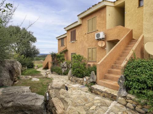 a house with a stone walkway next to a building at Apartment I-1-4 by Interhome in Golfo Aranci