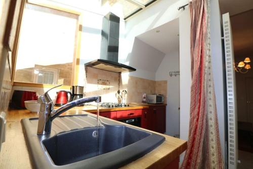 une cuisine avec un évier et une grande fenêtre dans l'établissement CLOS DU PRESIDIAL: ROMANTIC HIDEWAY IN THE MEDIEVAL SARLAT, à Sarlat-la-Canéda