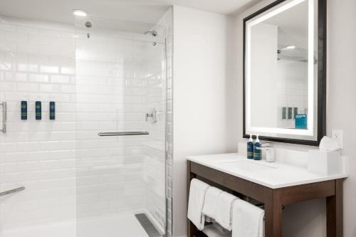 a bathroom with a glass shower and a sink at Four Points by Sheraton Kelowna Airport in Kelowna