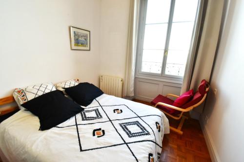 a bedroom with a bed with a black and white quilt at Appartement avec vue 180 sur le Lac Léman in Thonon-les-Bains
