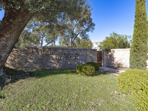 un mur en pierre avec un signe indiquant Domicionova dans l'établissement Apartment Domaine d'Arca G7 by Interhome, à Porto-Vecchio