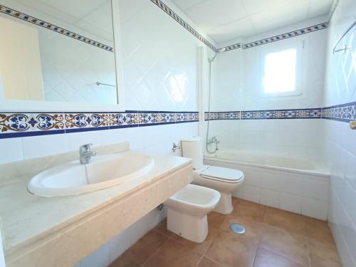 イスラ・カネラにあるURBANIZACIÓN SAN BRUNO II 2 DORM EN 1º PLANTAの洗面台とトイレを備えた白いバスルーム