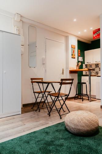 - un salon avec une table, des chaises et un tapis vert dans l'établissement Foch, au Havre