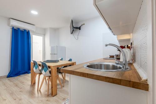 cocina con fregadero y mesa de madera en Bettatur Apartaments Via Imperi Romà en Tarragona