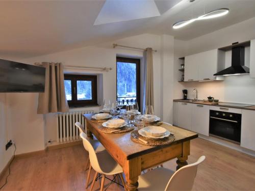 a kitchen with a wooden table and chairs in a room at Apartment Guanella Apartment by Interhome in Campodolcino