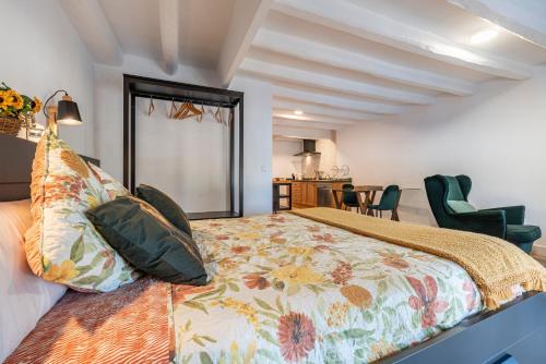 1 dormitorio con cama extragrande y colcha de flores en Bettatur Apartaments Via Imperi Romà en Tarragona