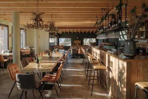 un restaurant avec des tables et des chaises et un bar dans l'établissement Dormio Resort Les Portes du Grand Massif, à Flaine