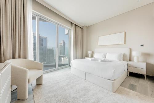 a bedroom with a white bed and a large window at Stayis - 1 BR Marina suite in Dubai