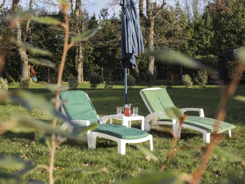 2 chaises et un parasol dans l'herbe dans l'établissement Holiday Home La Tingère by Interhome, à Pornic