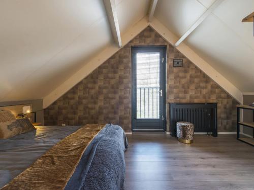 um quarto no sótão com uma cama e uma janela em Holiday Home VIP Wellness Ewijk by Interhome em Ewijk