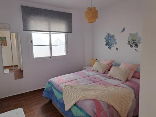 un dormitorio con una cama y una ventana en Ático Bella Vista, en Cómpeta