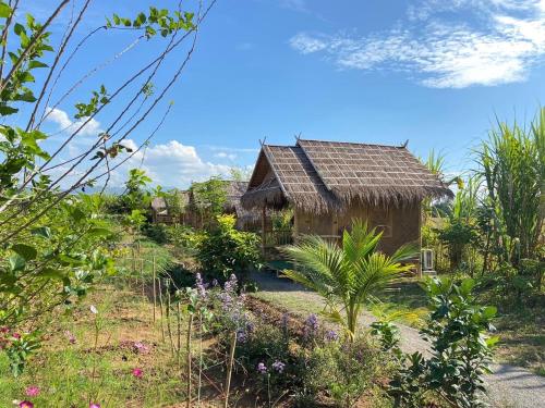 ein altes Haus inmitten eines Gartens in der Unterkunft บ้านสวนกางโต้ง Ban Suan Kang Tong in Chom Thong