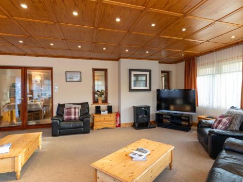 a living room with couches and a flat screen tv at Villa Craigmore Lodge by Interhome in Aviemore