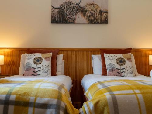 two beds sitting next to each other in a room at Villa Craigmore Lodge by Interhome in Aviemore