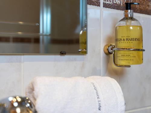 a bathroom with a towel and a bottle of alcohol at Villa Craigmore Lodge by Interhome in Aviemore
