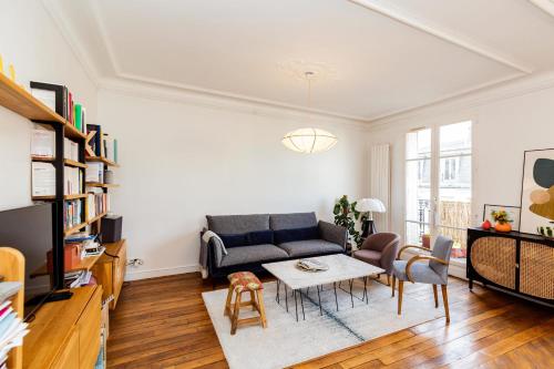 uma sala de estar com um sofá e uma mesa em Spacious luxury apartment near Monmartre em Paris