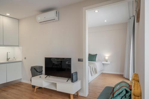 a white living room with a tv and a bed at Santa Luzia III by An Island Apart in Funchal
