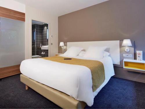 Un pat sau paturi într-o cameră la Kyriad Prestige Pau – Palais des Sports