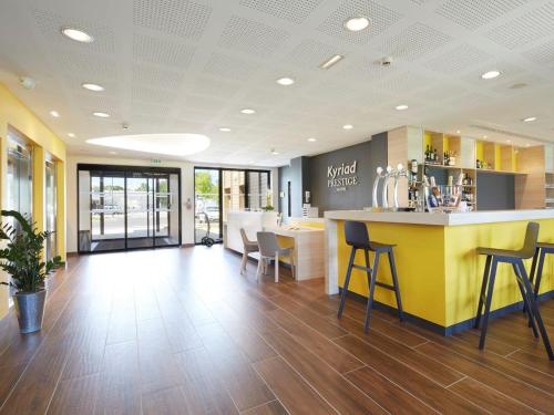 a lobby with a bar and chairs in a restaurant at Kyriad Prestige Pau – Palais des Sports in Pau