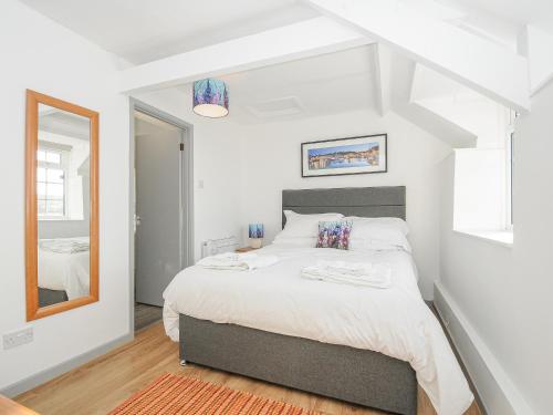 1 dormitorio con 1 cama grande y espejo en Manor Cottage Barn, en Callington
