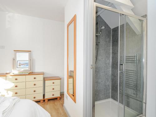 1 dormitorio con ducha y vestidor en Manor Cottage Barn, en Callington