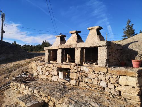 an old stone building with bells on top of it at Mountain Lodge T3 Duplex Abrigo do Lobo in Covilhã