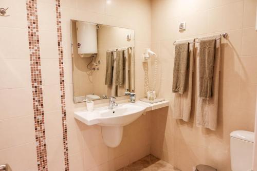 a bathroom with a sink and a mirror and a toilet at Hotel Acropolis in Varna City