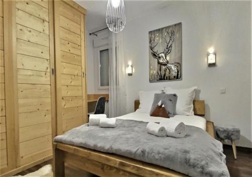 1 dormitorio con 1 cama grande y 2 toallas en Snow Home by So'SerenityHome-Jardin-Parking-Calme, en Marignier