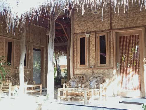 a patio with two chairs and a building at Azka Homestay in Kuta Lombok