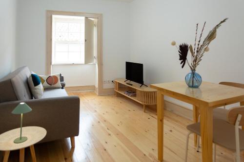 a living room with a couch and a table at Vinum Apartamentos 1890 in Coimbra