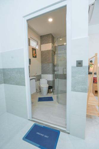 a bathroom with a toilet and a glass door at ALOHA SAIGON PREMIUM HOSTEL by Local Travel Experts - Newly opened, Less-touristy location, Spacious rooms, Glass shower bathroom, Free breakfast & Walking Tour in Ho Chi Minh City