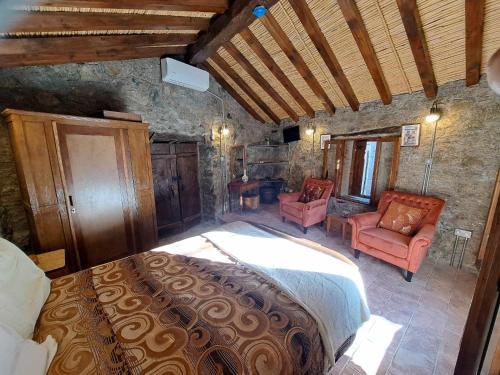 a bedroom with a large bed and two chairs at PITHARIA in Askas
