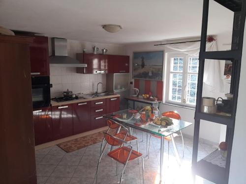 a kitchen with a glass table and some chairs at Casa belvedere in Sanfront