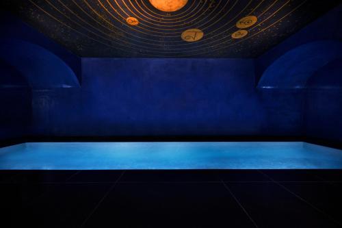 une chambre bleue avec une baignoire ornée d'une peinture de planètes dans l'établissement Maison Souquet, Hotel & Spa, à Paris