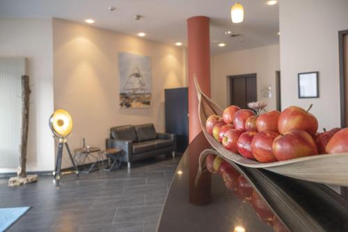 a bowl of apples on a table in a living room at Hotel Rhein-Ruhr Bottrop in Bottrop