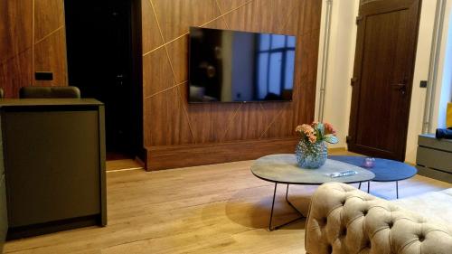 a living room with a table and a tv at TRESOR Delux Apartment in Osijek