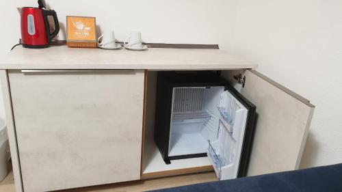 a small kitchen with a refrigerator under a counter at Ferienwohnung und Pension Antje Ekert in Uhldingen-Mühlhofen