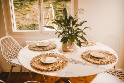 a white table with plates and a plant on it at Maison Bobochic parking et jardin by Art de Voyager in Étretat