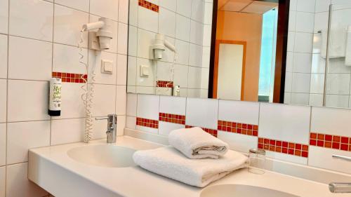 ボトロップにあるHotel Rhein-Ruhr Bottropの洗面台と鏡のあるバスルーム