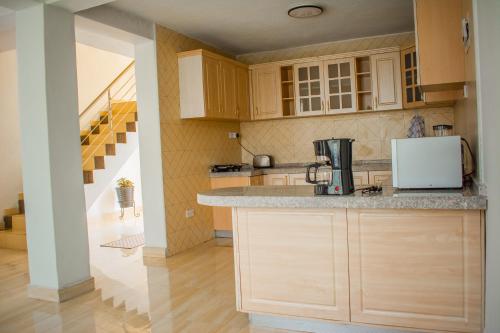 cocina con armarios de madera y encimera en Divine Heights Bed and Breakfast Lilongwe Area 43, en Lilongwe