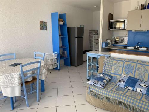 - une cuisine avec un canapé et une table dans une chambre dans l'établissement Appartement 2 pièces avec piscine et parking à Port Camargue - FR-1-250-113, au Grau-du-Roi