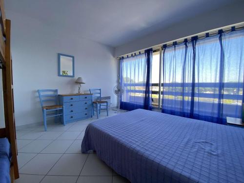 une chambre avec un lit, un bureau et des fenêtres dans l'établissement Appartement 2 pièces avec piscine et parking à Port Camargue - FR-1-250-113, au Grau-du-Roi