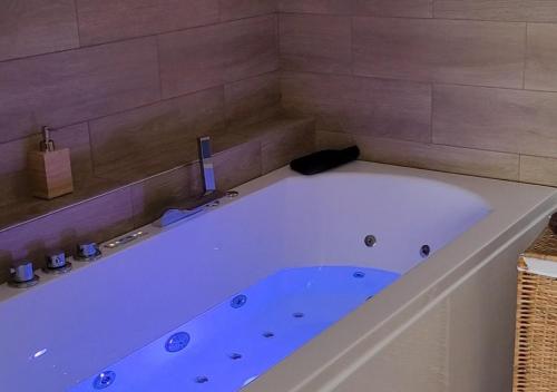 a large white bath tub in a bathroom at Les 3 Bulles in Gueux
