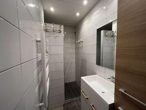 uma casa de banho branca com um lavatório e um espelho em Appartement Marseillan-Plage, 2 pièces, 4 personnes - FR-1-387-109 em Marseillan