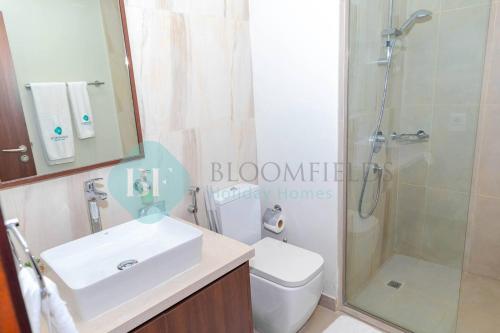a bathroom with a sink and a shower and a toilet at Modern 1 Bedroom In Reflections in Abu Dhabi