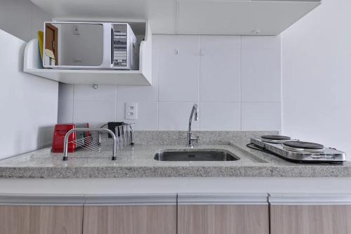 eine Küche mit einer Spüle und einer Mikrowelle in der Unterkunft Piscina aquecida Vista Romântica Estacionamento in Osasco