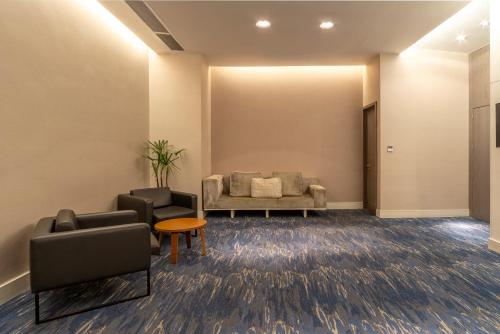 a waiting room with a couch and chairs at Lifestyle Laghetto Collection in Rio de Janeiro